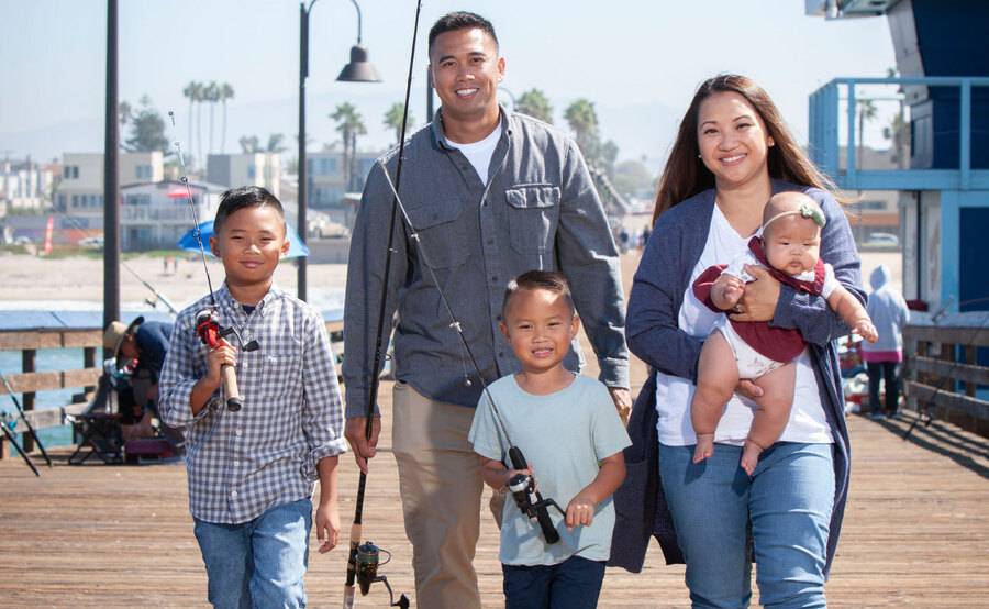 A Scripps cancer patient walks with her young family on a pier, representing a cancer story of hope and survival.