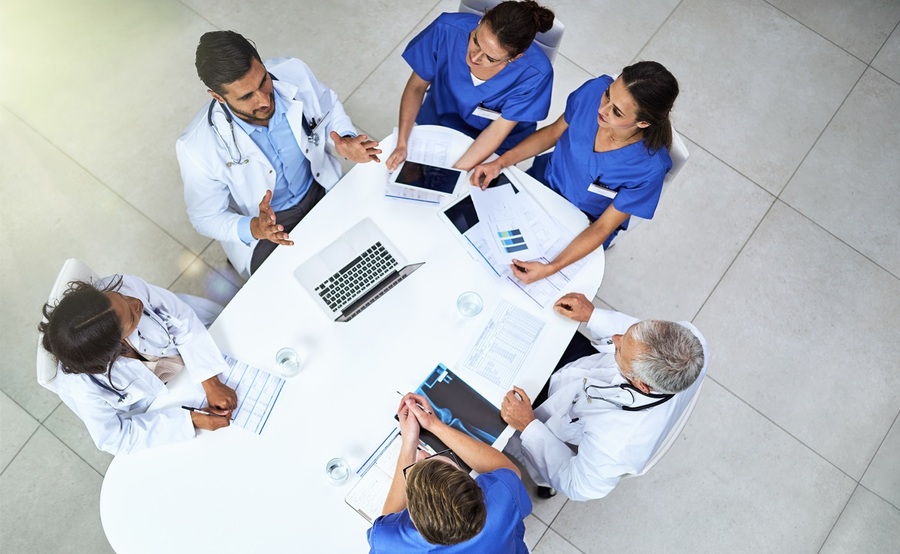 An aerial view of physicians in discussion around a table represents the evidence-based environment of the Scripps Clinic Internal Medicine Residency Program.