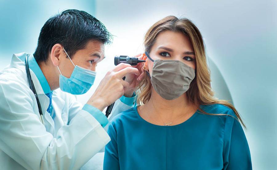 Scripps Coastal family physician Dr. Anthony Chong uses an otoscope to look inside a patient's ear.