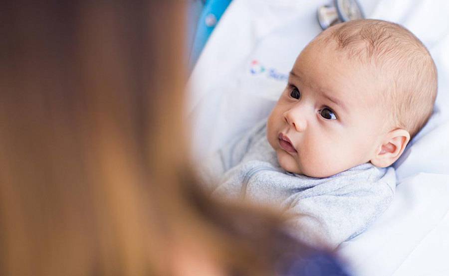 A health care provider cradles an infant, representing children of all ages treated at Scripps HealthExpress Carmel Valley.