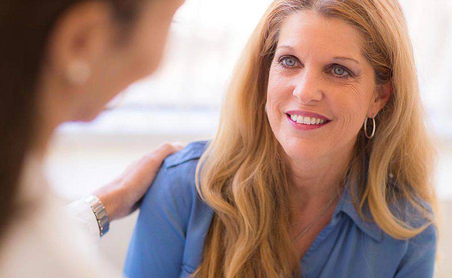 A nurse practitioner puts a comforting hand on a woman's shoulder at a Scripps walk-in clinic that offers care for minor illnesses and injuries.