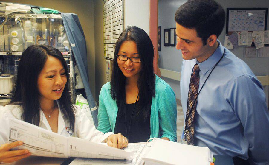Two pharmacy residents listen to a faculty member in a stockroom as part of their residency training at Scripps in La Jolla.