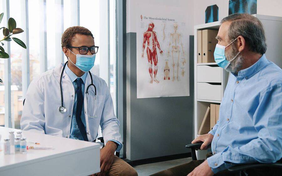 A young black male oncologist and a mature white male patient represent the lung cancer screening program at Scripps.
