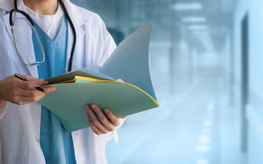 A man looks at papers in a folder, similar to a health provider's review of Scripps medical records.