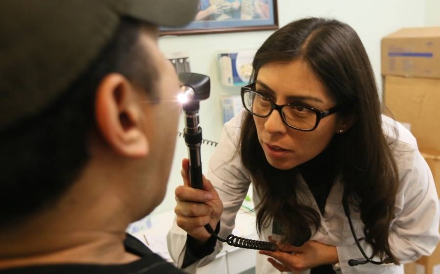 A Scripps doctor checks the mouth and throat of a low-income La Jolla resident as part of his checkup routine.