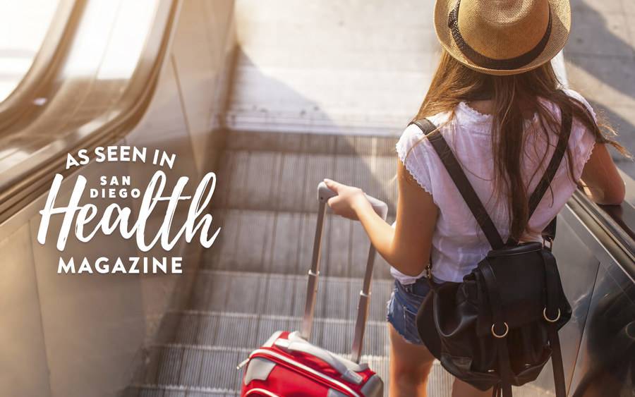 Young woman going down escalator with her travel bags.