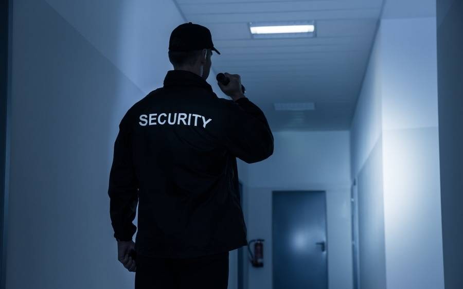 A security officer checks out an area in the building to make sure everything is safe.