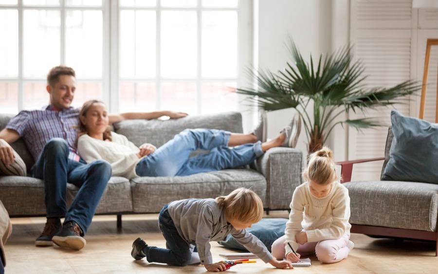 A family of four playing together with each other in the living room.