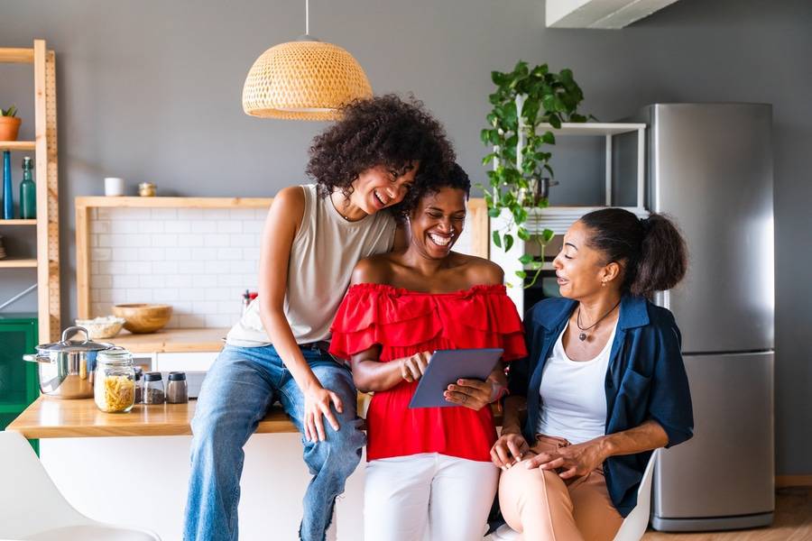 Three Black women gather in the kitchen to discuss heart healthy activities.