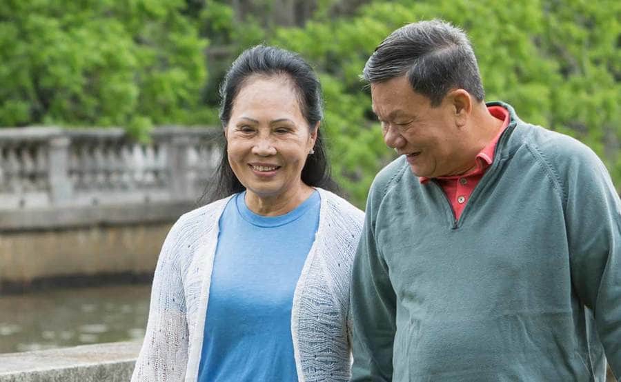 A smiling mature Asian couple represents the power and value of knowing skin cancer symptoms.