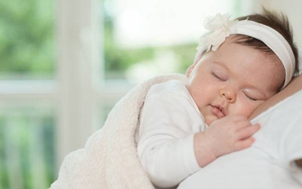 A sleeping infant rests in a pleasant indoor space