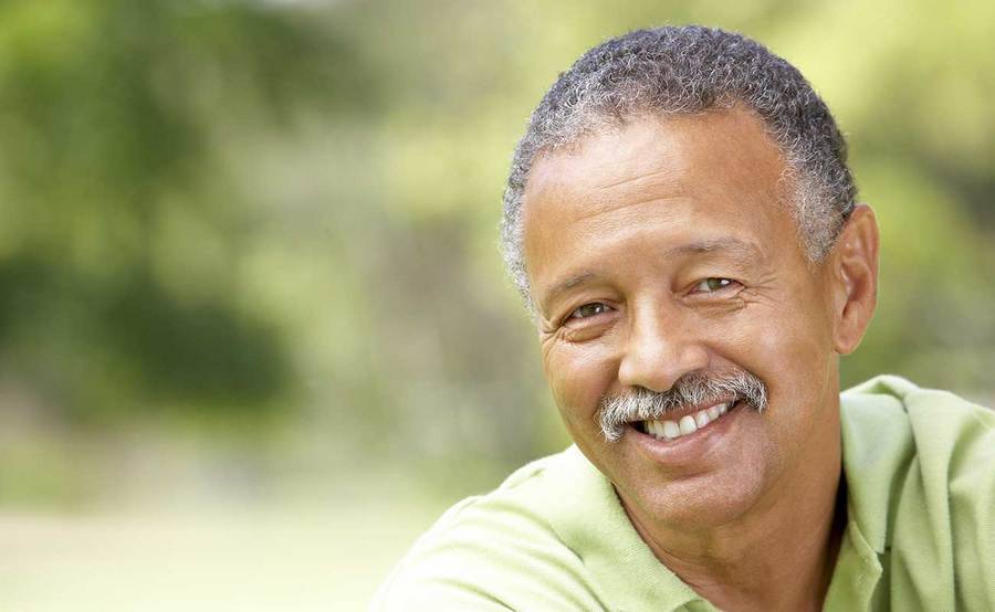 A smiling middle-aged African-American man represents the full life that can be led after soft tissue sarcoma treatment.