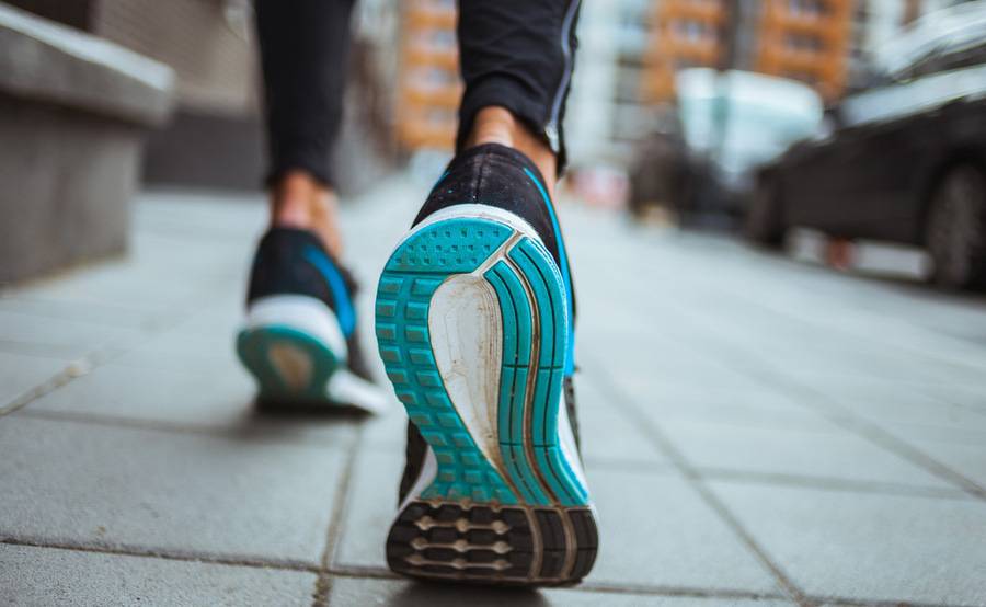 The bottom of a runner's cross-trainer as it's coming off the pavement.