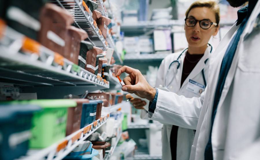 Two pharmacists check inventory at hospital pharmacy, representing Scripps Health Specialty Pharmacy.