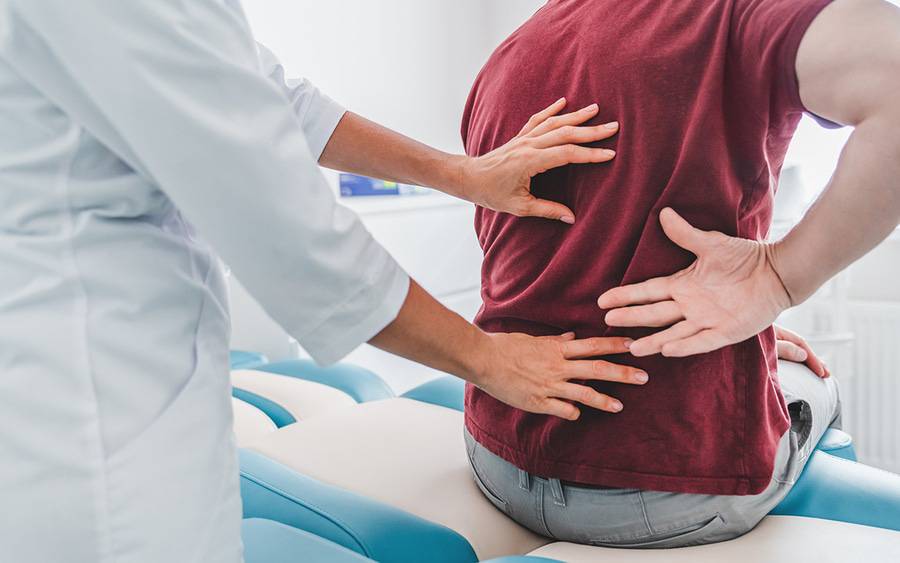 A back specialist examines a patient.