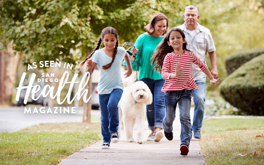 A family of four enjoy a walk on a summer day. 