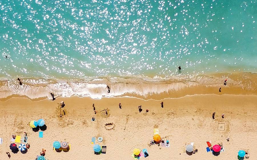 People sunbathing, protecting against sun burn, social distancing.