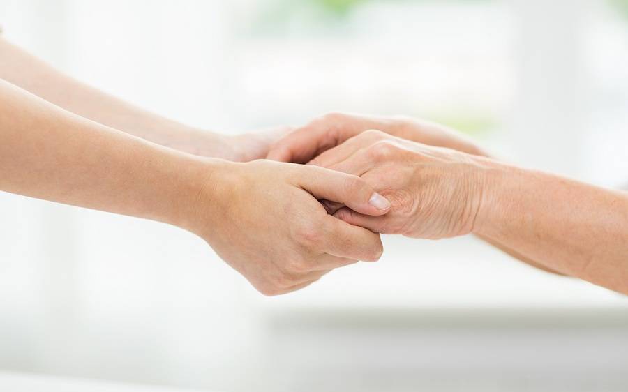 Two hands join in a gesture of support