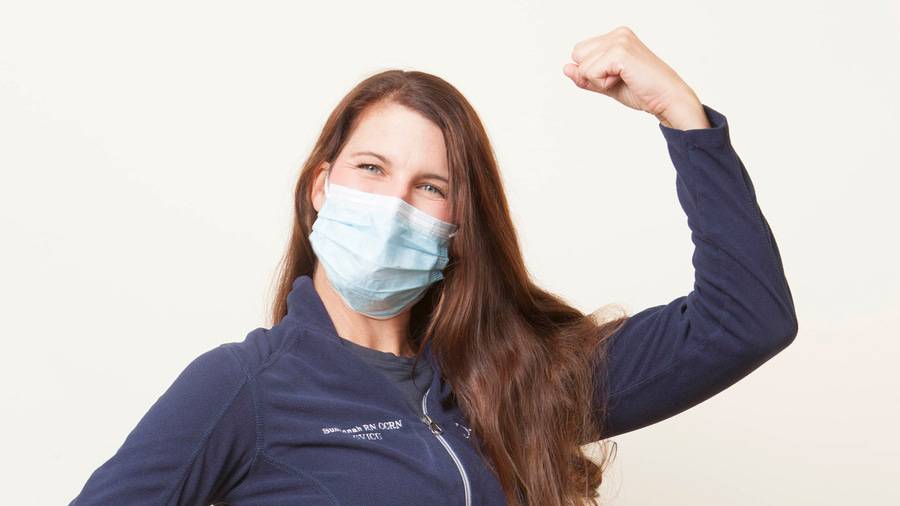 Susannah Hensel, RN wearing a face mask with her arm up in a gesture of strength, one of the eight Scripps Nurses of the Year 2020. 