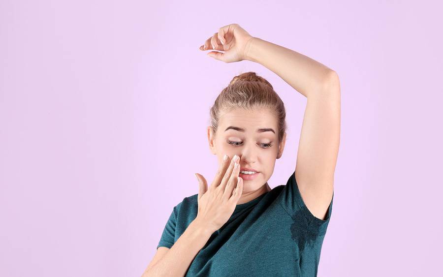 Young girl with sweaty underarms that could be sign of hyperhidrosis.