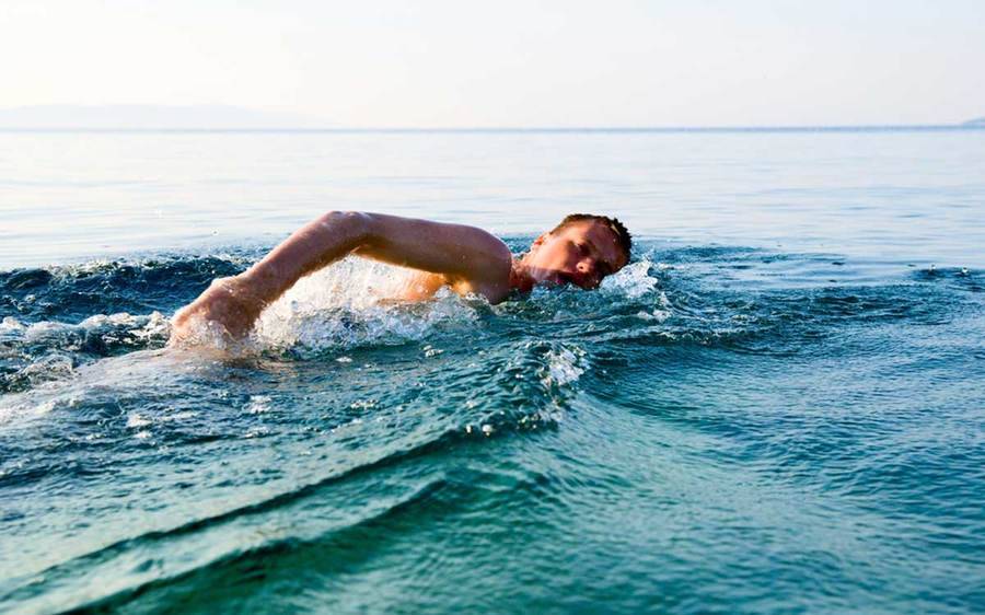 A man swims in the ocean, unaware of water related skin infections, which is a topic covered by a Scripps physician.