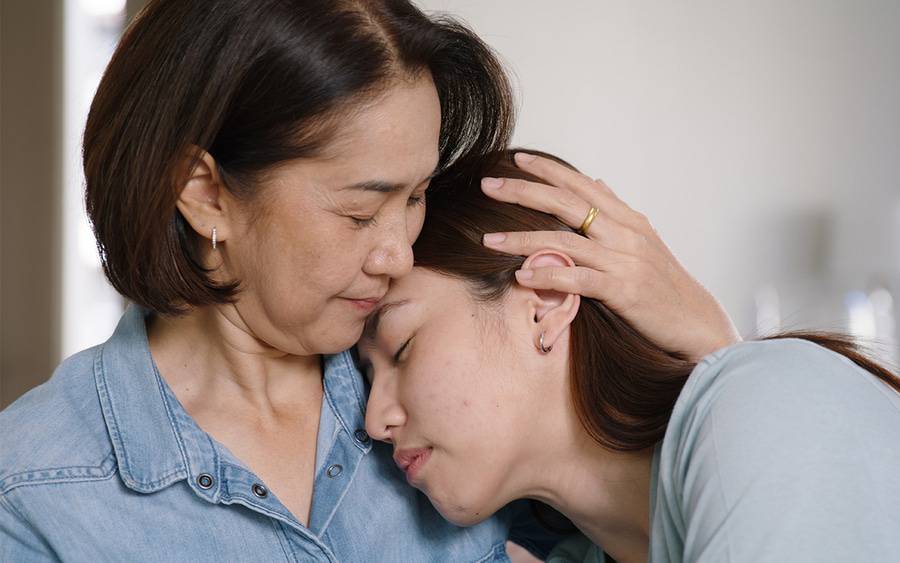 A mother comforts her daughter who has depression.