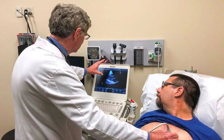 Scripps physician Thomas Heywood examines heart patient Scott Fitzgerald