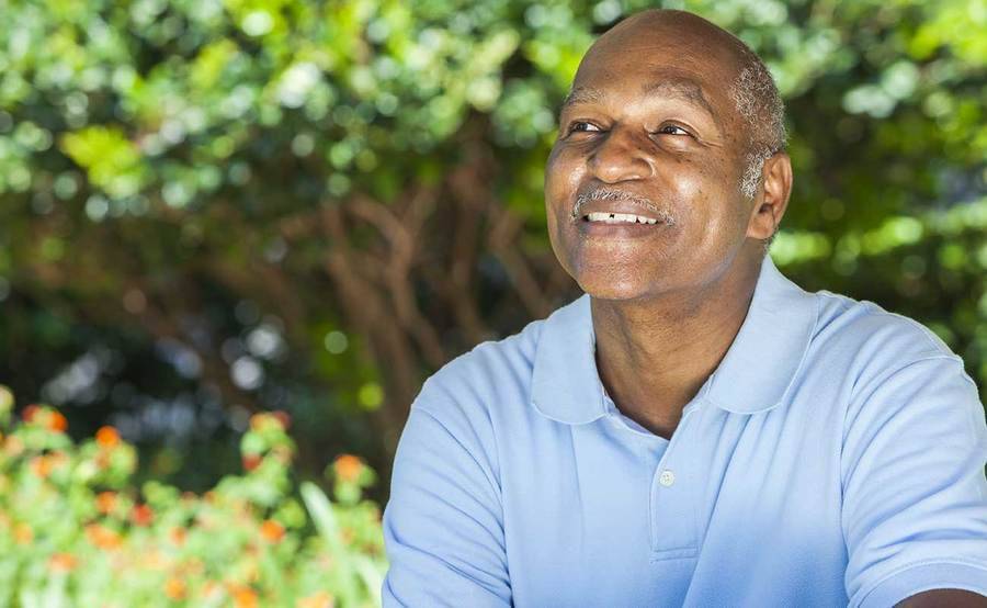 A smiling African-American man represents the full life that can be led after laryngeal or hypopharyngeal cancer treatment.