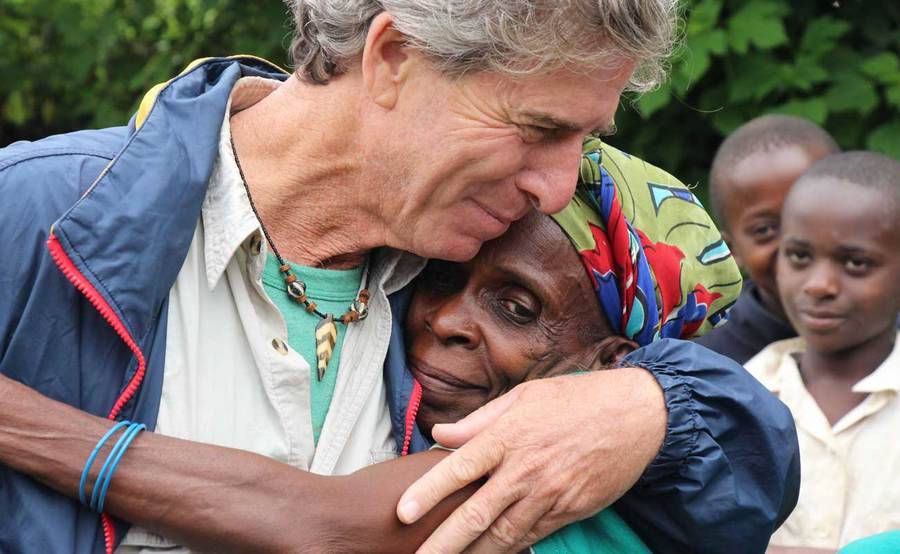 Biologist Bill Toone hugs a woman in Africa.