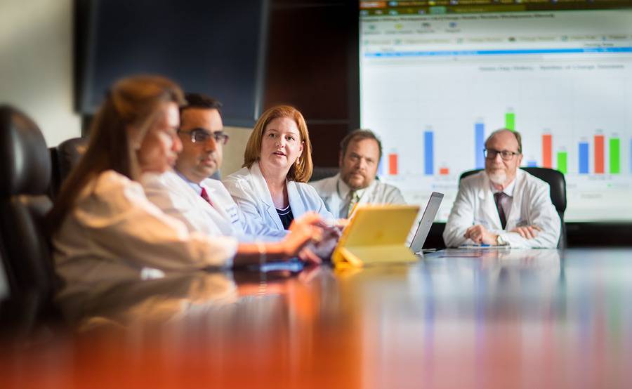 Drs. James Mason, Jeffery Andrey, Catherine Frenette, Anuj Mahindra and Angeles Baquerizo, of Scripps Center for Organ and Cell Transplantation, sit at a large table in a conference room.