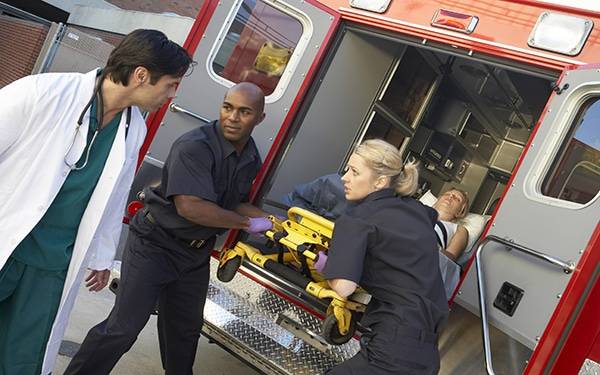 Paramedics and doctor taking patient out of ambulance