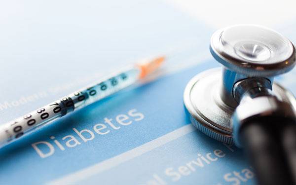 Diabetes medication and a stethoscope rest on literature about diabetes that details myths about Type 2 diabetes.