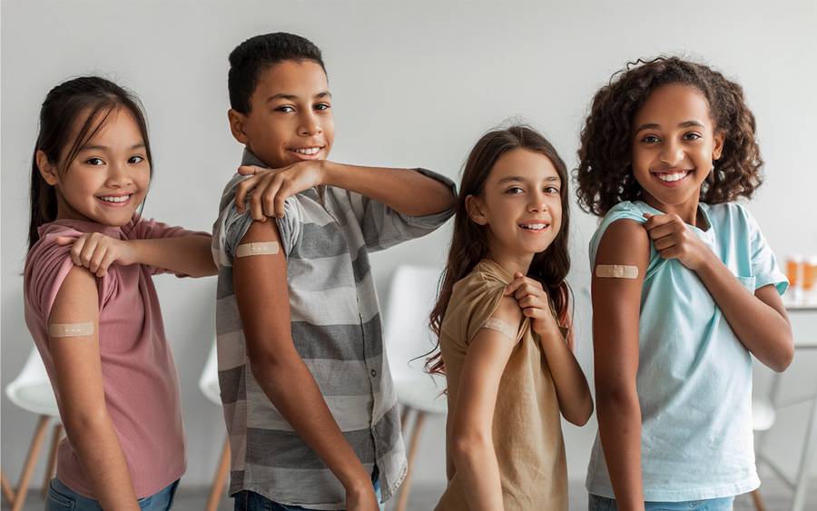 A group of kids show off their bandages as proof they received their vaccines.