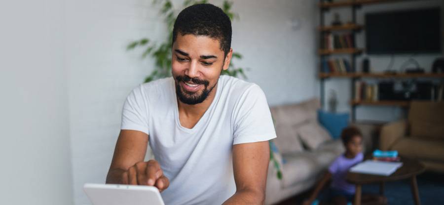 A man uses a tablet, representing an online symptom checker.