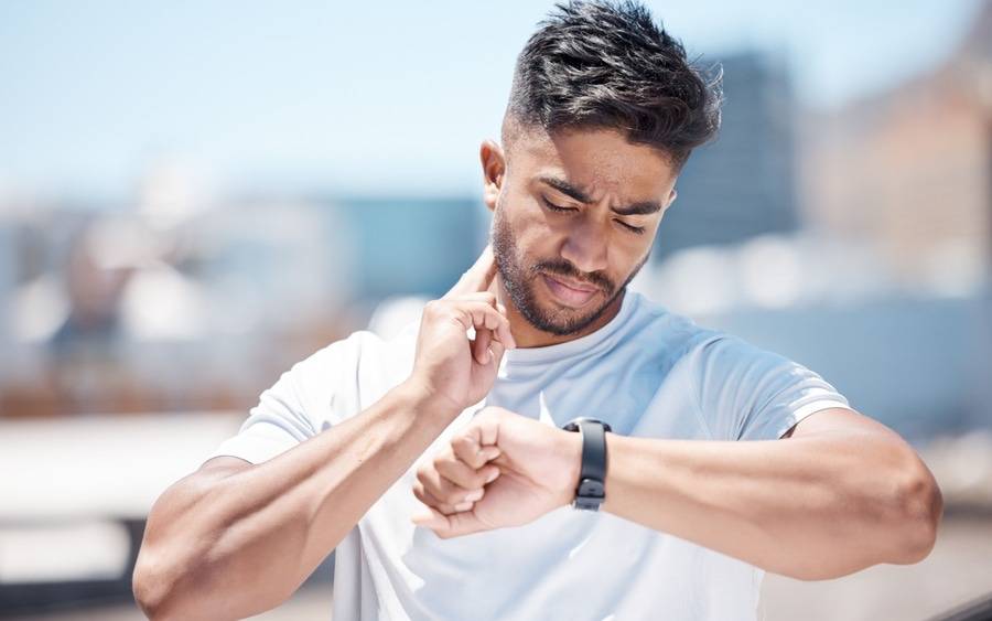 A man checks his heart rate using a wearable device after working out.