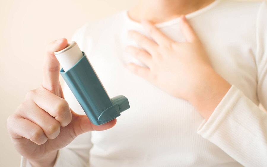 Woman with COPD holds an inhaler.