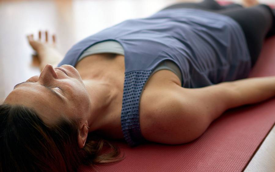 A woman practicing restorative yoga. 