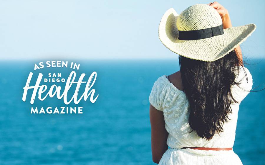 Woman with hat sits in the sun and gets vitamin D.