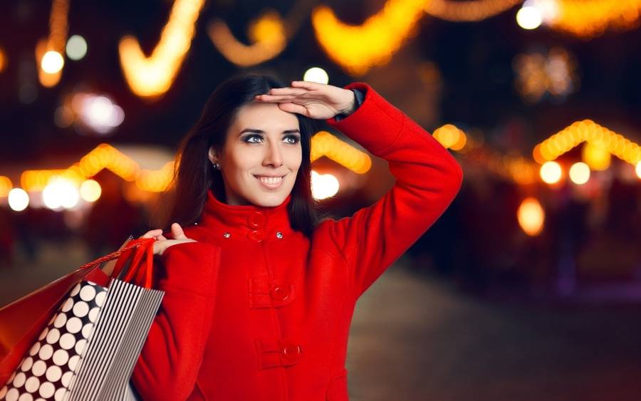 Woman smiles while shopping for Christmas gifts.