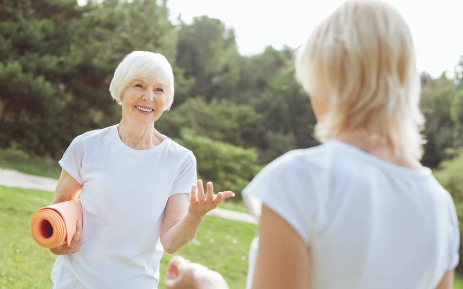 Woman in her 50s prepares to do heart-healthy yoga exercising for her heart health.