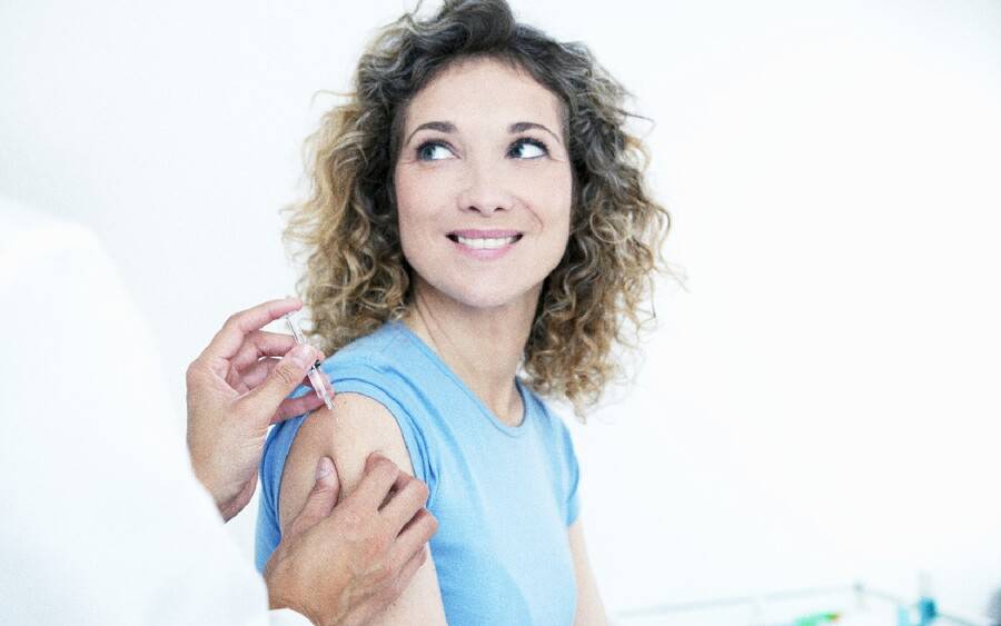 A woman smiles after getting her annual flu shot at her doctor's office.