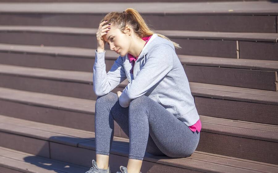 A young woman considers whether or not to exercise since she's sick.