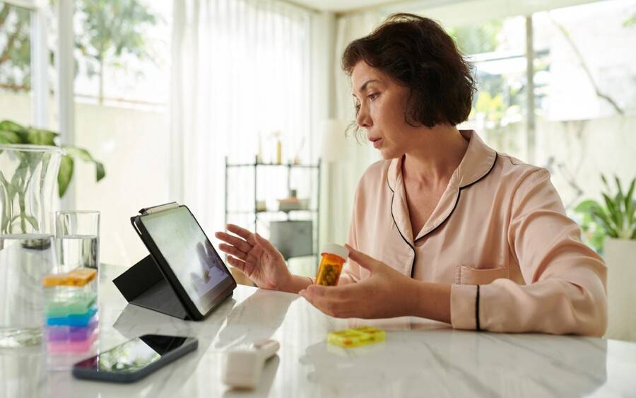 An older woman goes over her medication with her doctor during a video visit using MyScripps.