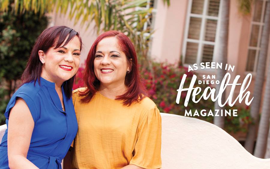 Sisters Michelle Paixao and Melissa Romberg sitting outside and smiling.