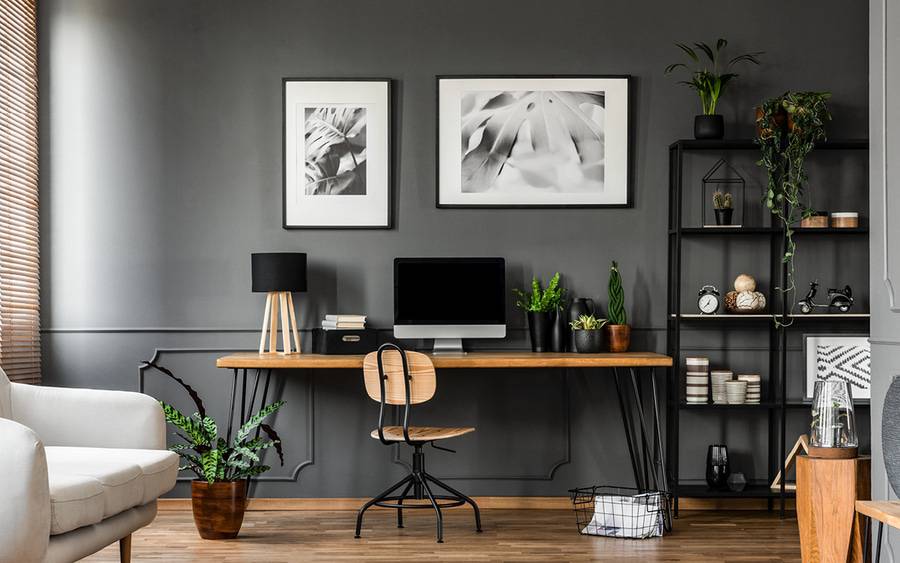 Desk with a computer and lamp in a home office.