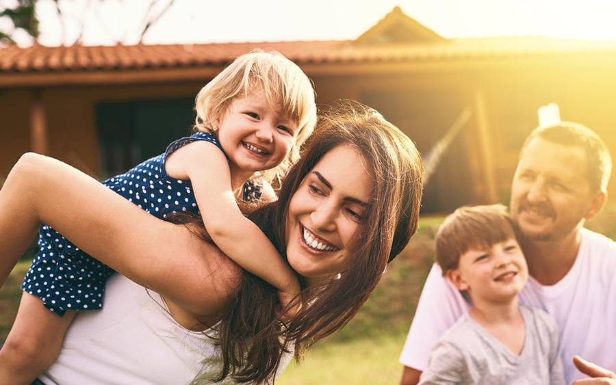 A young healthy family enjoy playing outside in the sun.