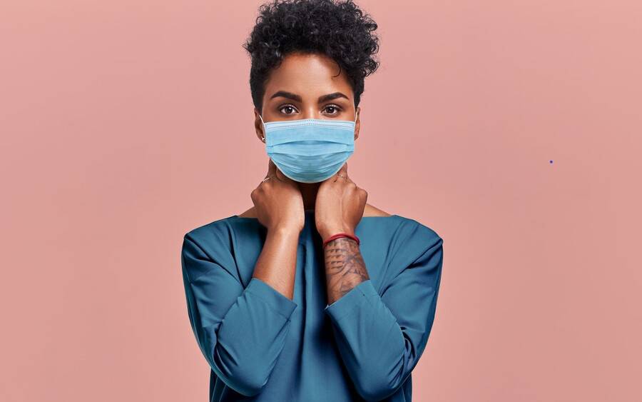 Young African-American woman wears a face mask to protect from coronavirus exposure.