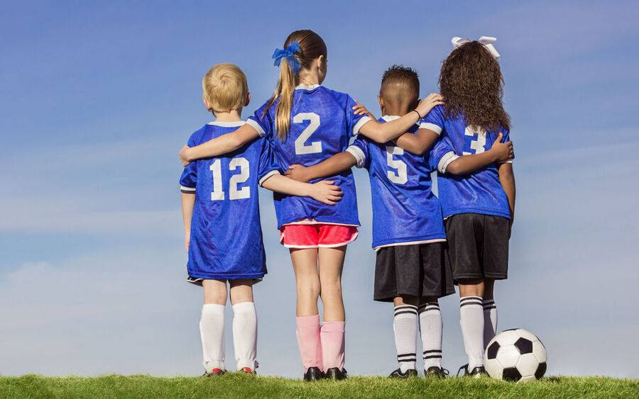 Kids huddle before playing soccer.