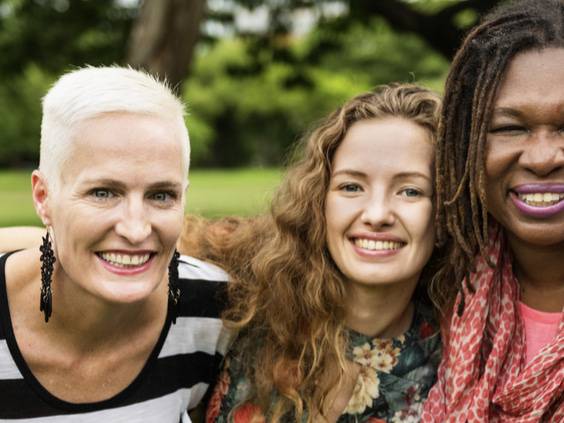 A group of smiling women with heart conditions put their arms around each other in support.