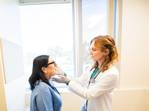 A Scripps provider examines a patient standing up.